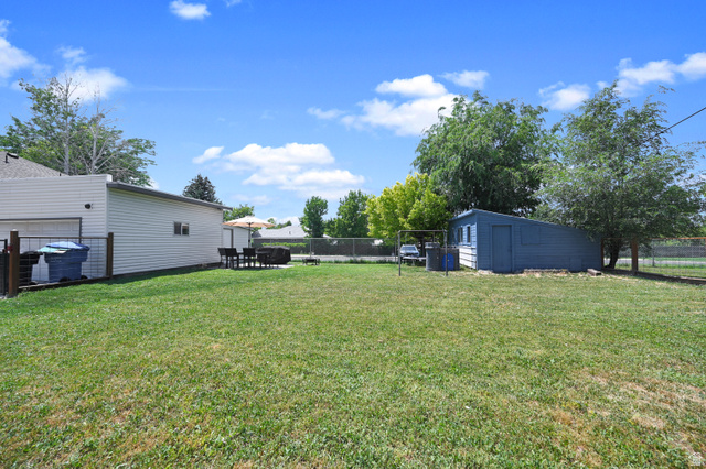 331 West 300 North Logan, UT 84321 - Photo 22 of 28 Grassy yard area featuring mature trees and a detached shed structure
