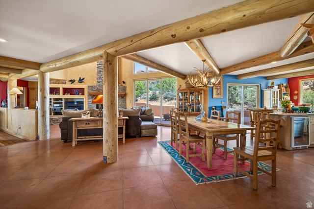 3617 Red Rock Drive Moab, UT 84532 - Photo 17 of 79 Dining room featuring wine cooler, a chandelier, healthy amount of natural light, tile patterned floors, and lofted ceiling with beams