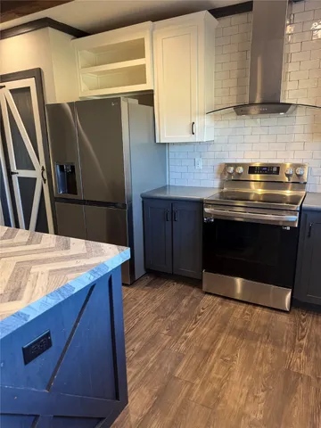 a kitchen with stainless steel appliances granite countertop a stove a refrigerator and a sink