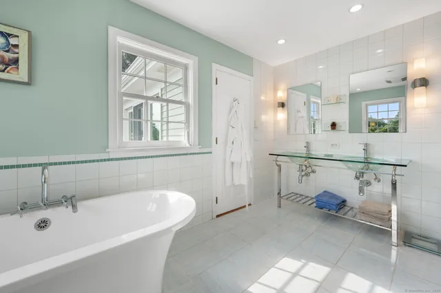 a bathroom with a tub sink and mirror
