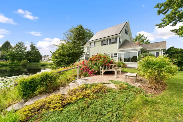 a view of a house with backyard sitting area and garden