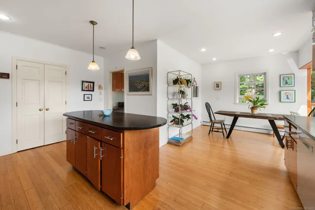 a kitchen with stainless steel appliances granite countertop a sink a stove and a wooden floors