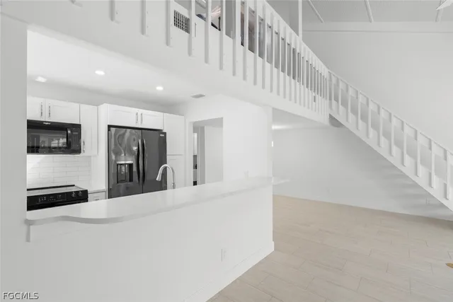a view of a kitchen with refrigerator and a stove top oven