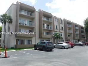 7747 Southwest 86th Street, Unit D411 Miami, FL 33143 - Photo 3 of 17 a building with car parked