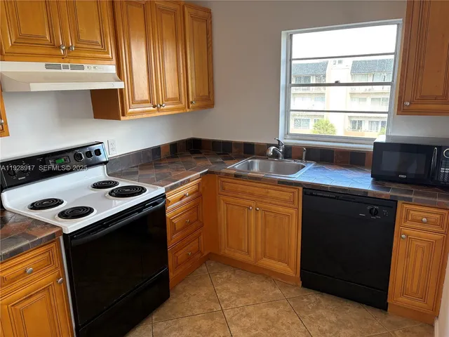a kitchen with a sink stove top oven and cabinets