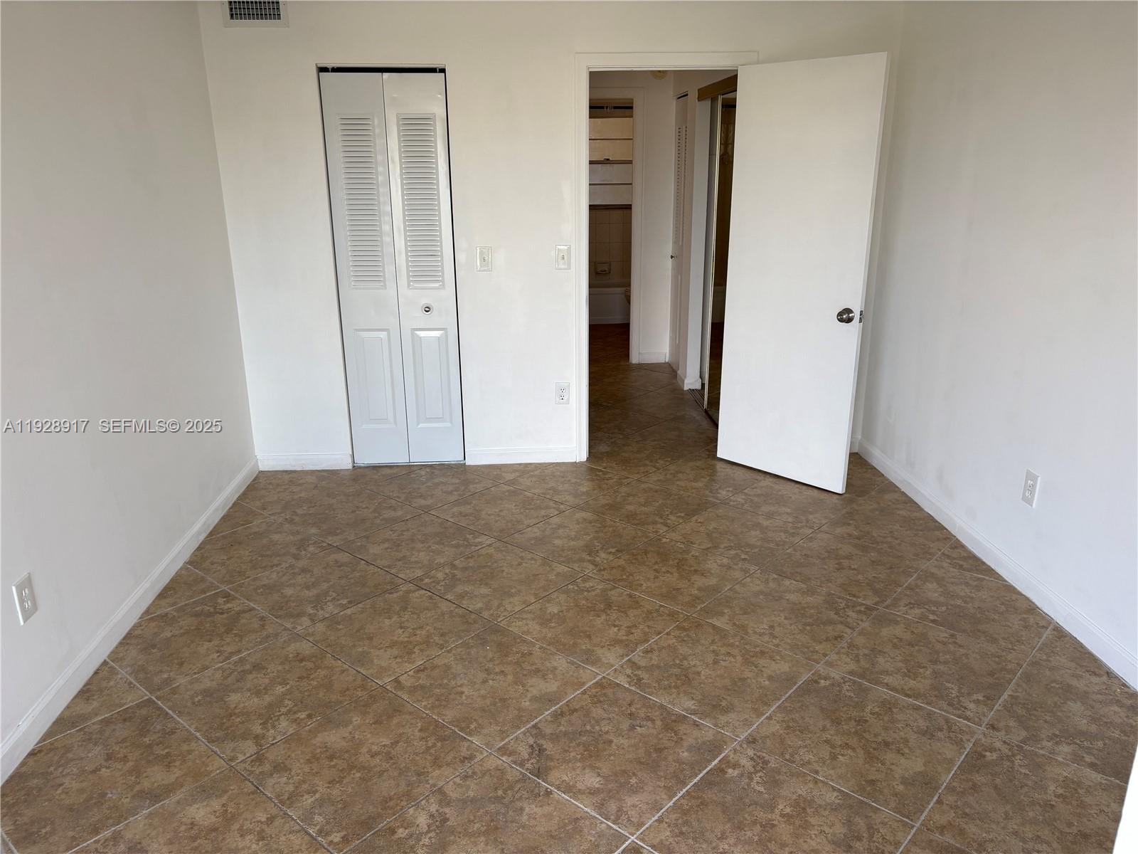 7747 Southwest 86th Street, Unit D411 Miami, FL 33143 - Photo 8 of 17 an empty room with closet