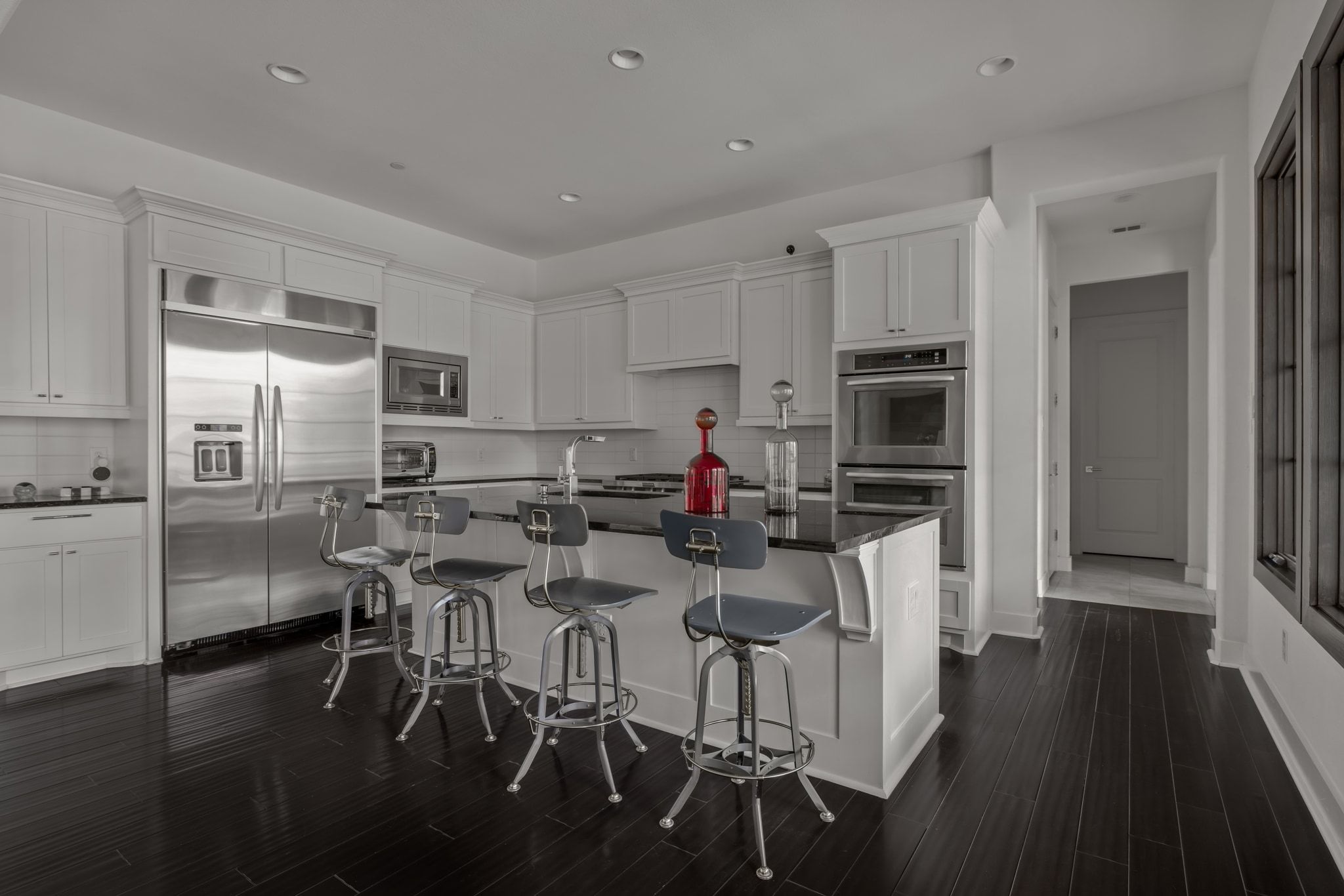 4720 Rockcliff Road, Unit 1 Austin, TX 78746 - Photo 16 of 39 A sleek culinary space showcases dark wood flooring and a large center island with bar seating.