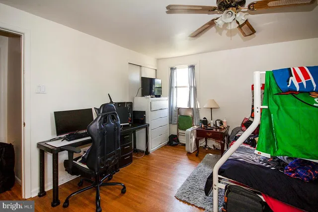 a view of a workspace with furniture and a ceiling fan
