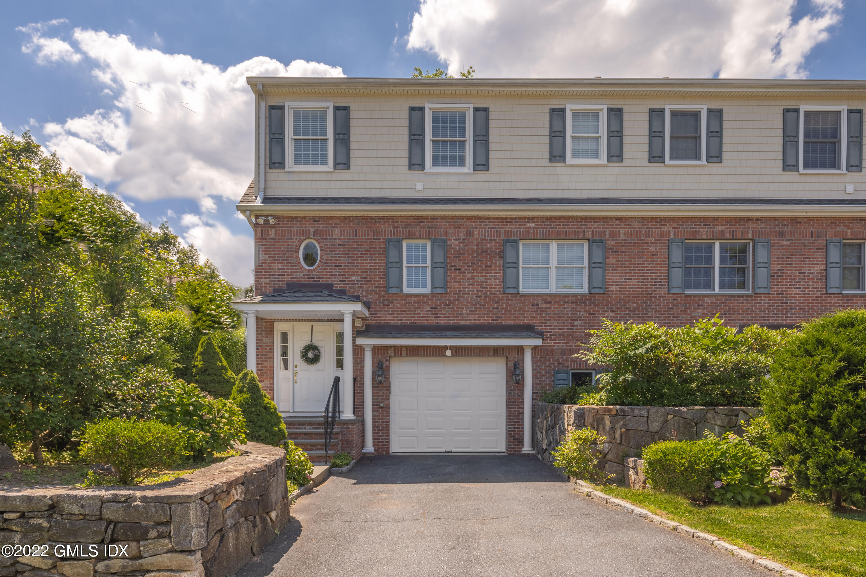 34 Windy Knolls, Unit B Greenwich, CT 06831 - Photo 2 of 37 a front view of a house with a yard garage and outdoor seating