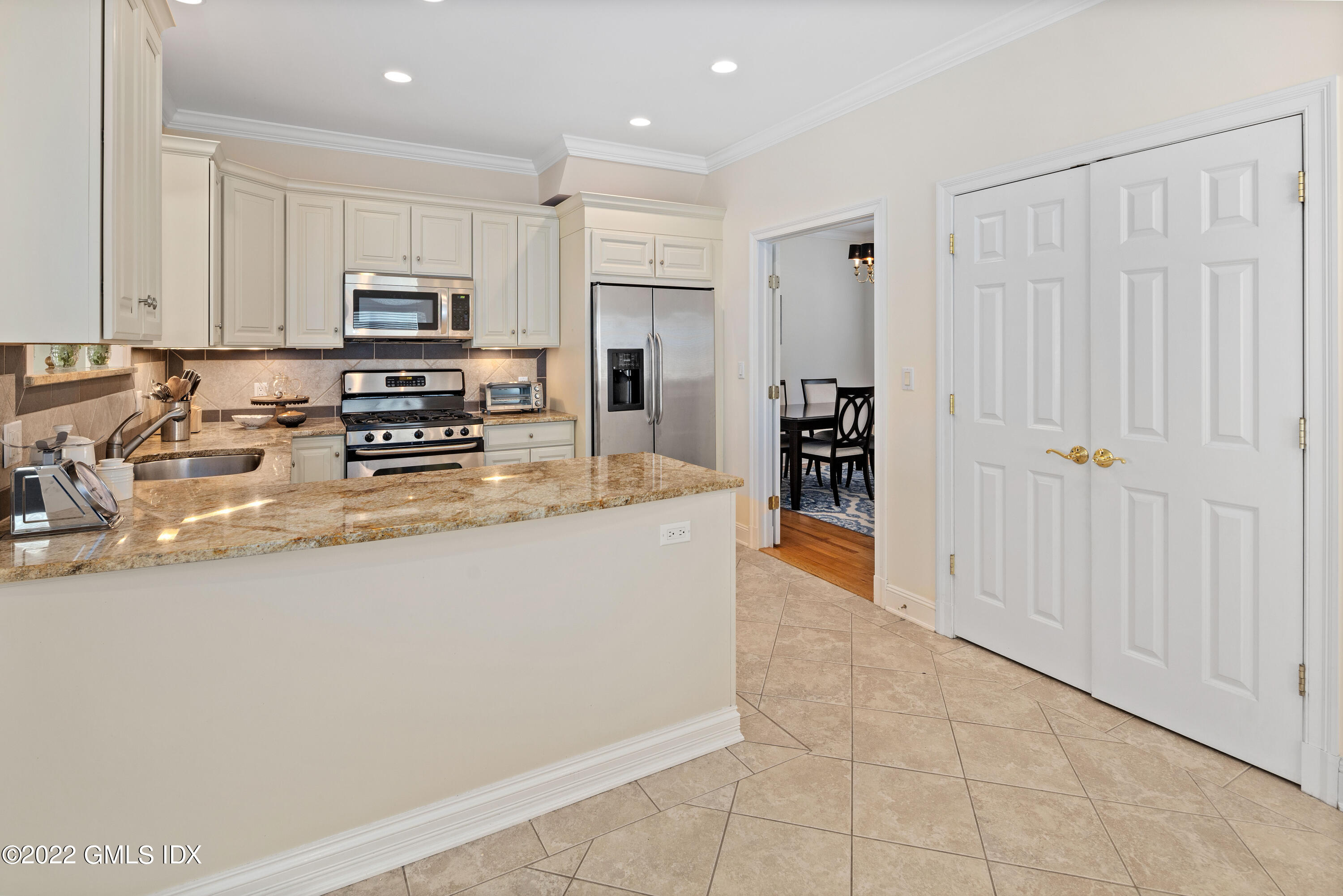 34 Windy Knolls, Unit B Greenwich, CT 06831 - Photo 9 of 37 a large kitchen with kitchen island granite countertop a stove a sink a refrigerator and white cabinets