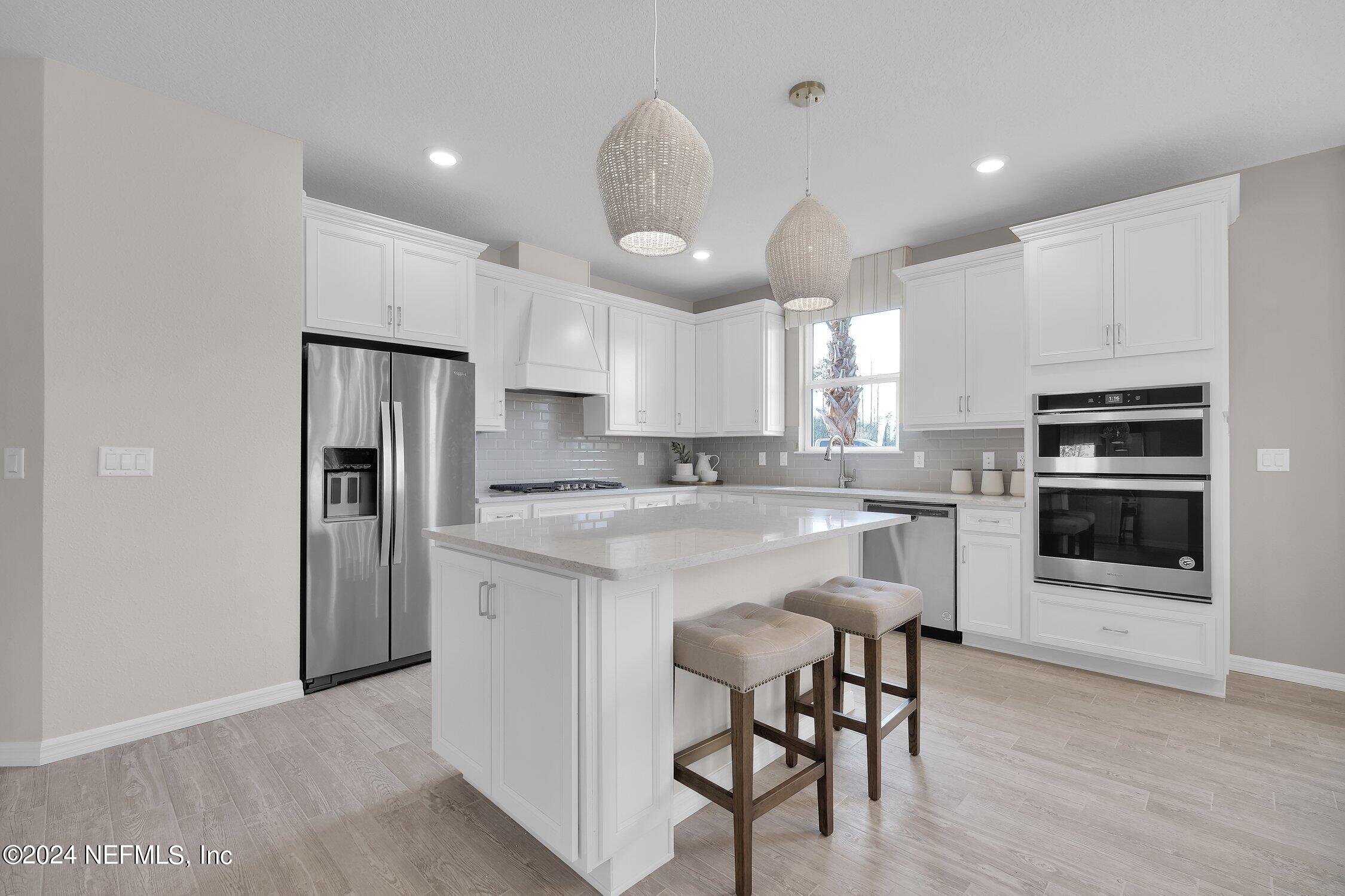 330 Salt Meadow Loop Yulee, FL 32097 - Photo 4 of 20 a kitchen with stainless steel appliances granite countertop a white cabinets and a refrigerator