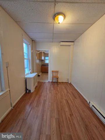 a view of a room with wooden floor furniture and windows