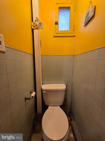 a white toilet sitting next to a bathroom