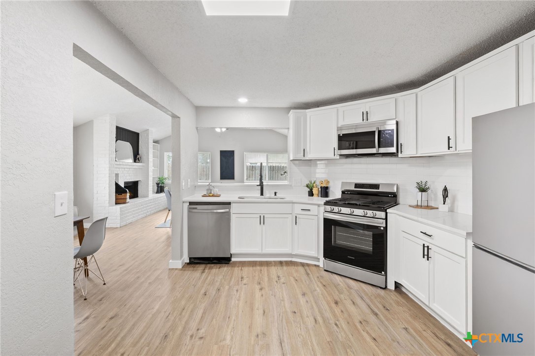 804 Antelope Trail Temple, TX 76504 - Photo 12 of 32 a kitchen with a sink cabinets and wooden floor