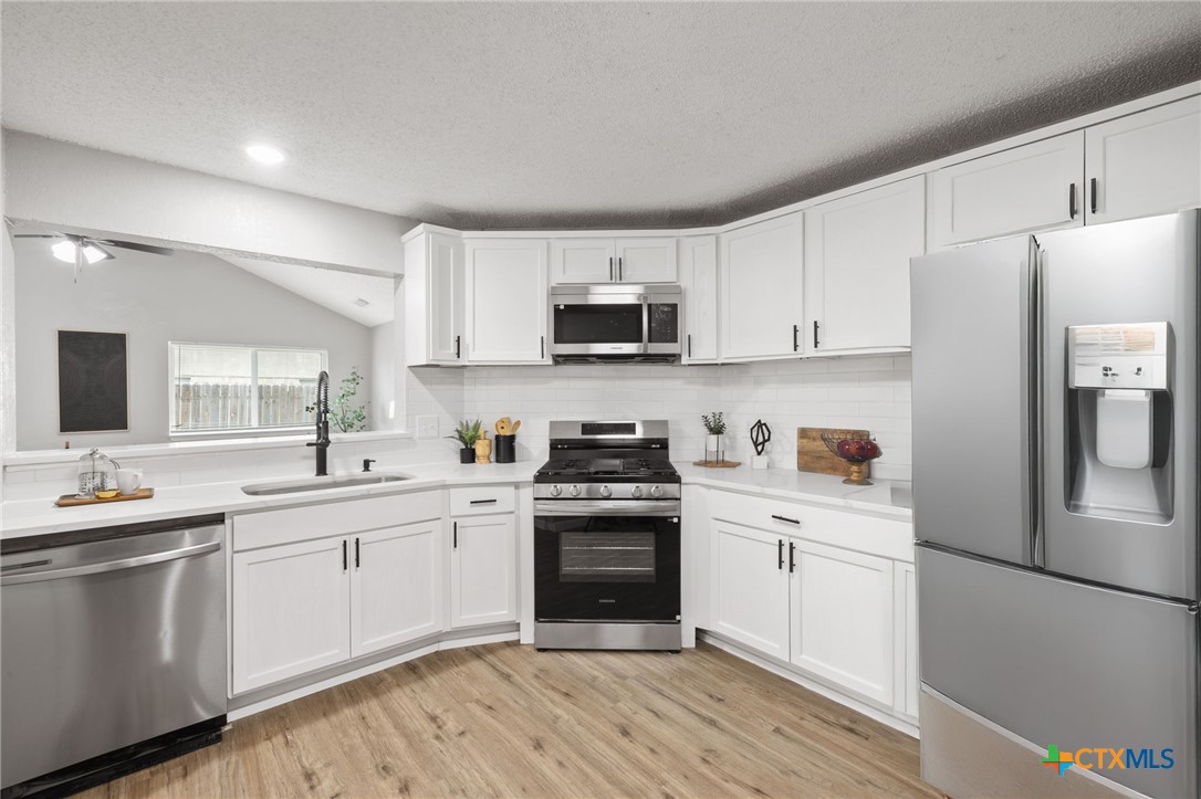 804 Antelope Trail Temple, TX 76504 - Photo 15 of 32 a kitchen with stainless steel appliances granite countertop a stove top oven a sink and white cabinets