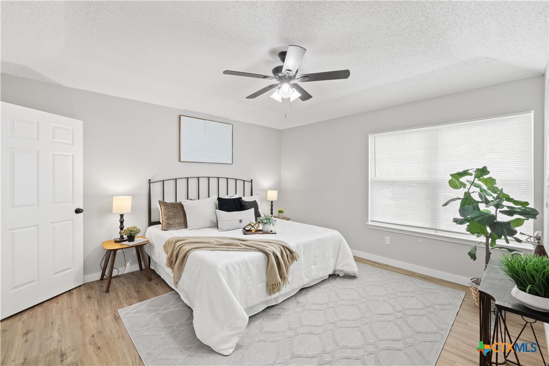 804 Antelope Trail Temple, TX 76504 - Photo 16 of 32 a bedroom with a bed lamp and a potted plant