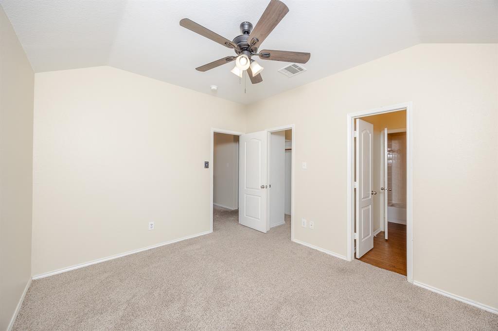 1828 Mercer Way Savannah, TX 76227 - Photo 23 of 38 Unfurnished bedroom with vaulted ceiling, a walk in closet, light carpet, and ceiling fan