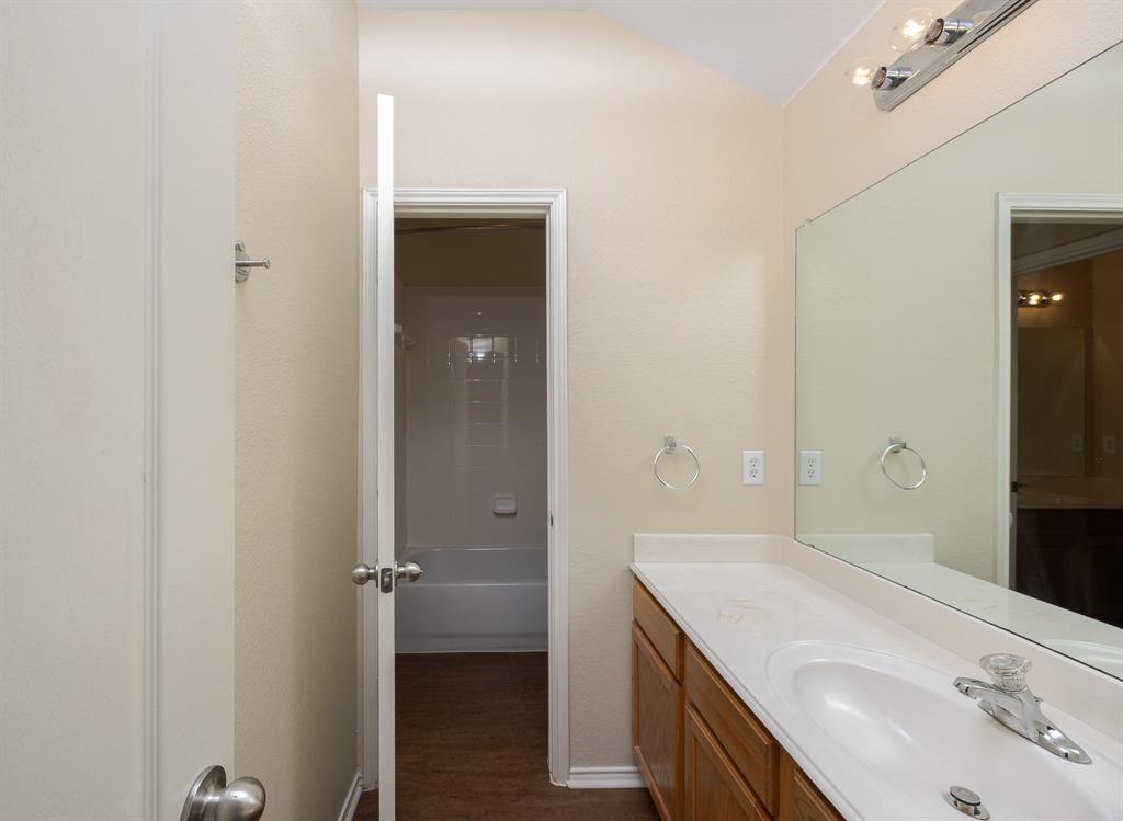 1828 Mercer Way Savannah, TX 76227 - Photo 24 of 38 Full bathroom with vanity, bathtub / shower combination, dark wood-type flooring, and vaulted ceiling