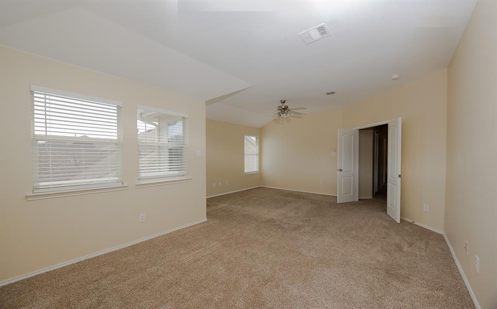 1828 Mercer Way Savannah, TX 76227 - Photo 30 of 38 Empty room with light carpet, lofted ceiling, and a ceiling fan