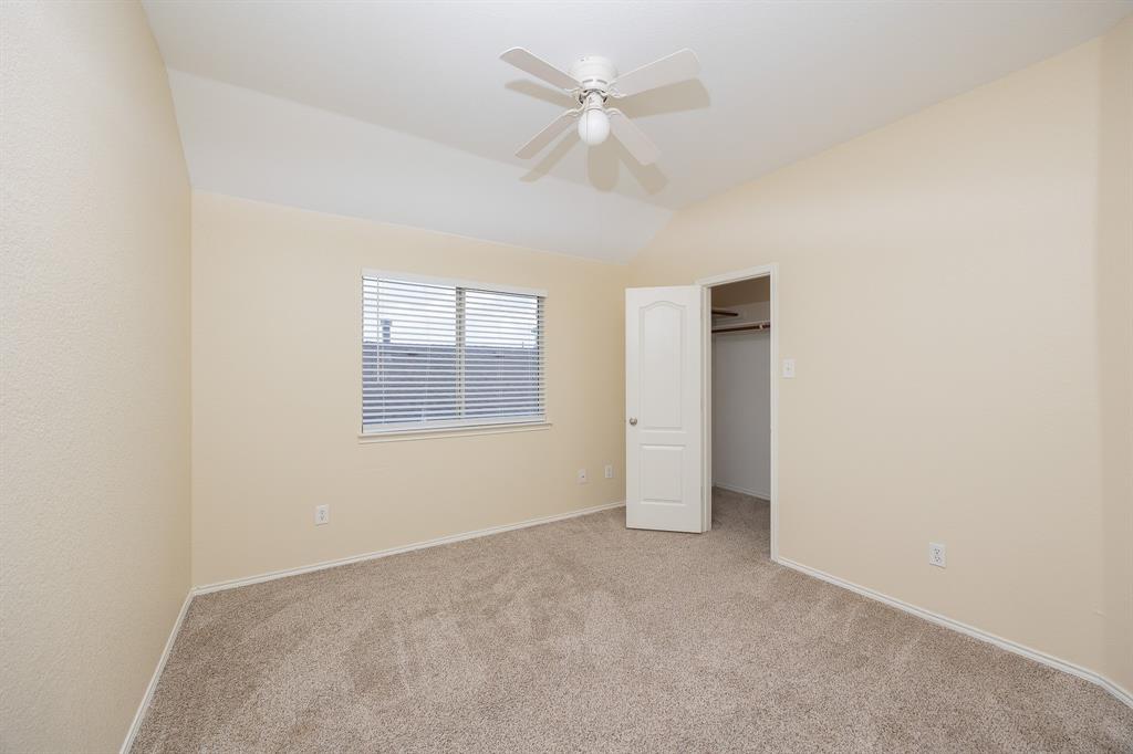 1828 Mercer Way Savannah, TX 76227 - Photo 33 of 38 Unfurnished bedroom featuring a spacious closet, carpet flooring, ceiling fan, and vaulted ceiling