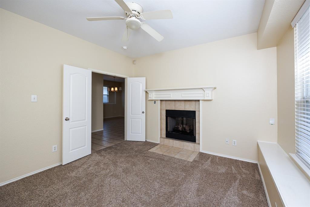 1828 Mercer Way Savannah, TX 76227 - Photo 6 of 38 Unfurnished living room with a fireplace, carpet, and a ceiling fan