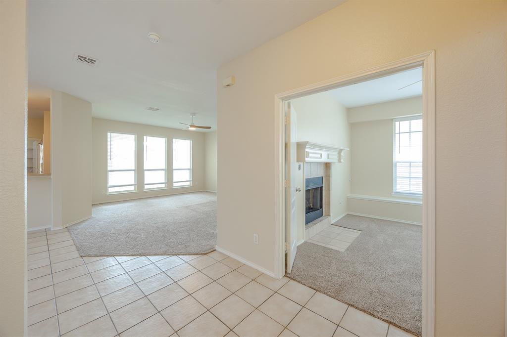 1828 Mercer Way Savannah, TX 76227 - Photo 7 of 38 Spare room with light colored carpet, light tile patterned flooring, a tile fireplace, and ceiling fan