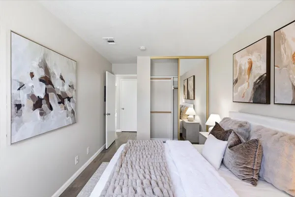 a bedroom with a bed and a painting on the wall