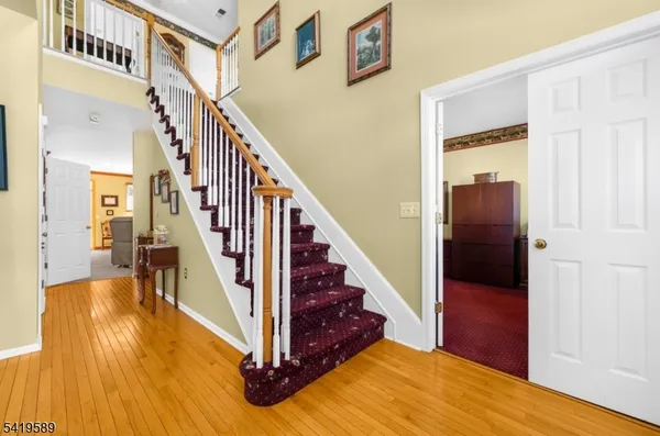 a view of a hallway with wooden floor and staircase