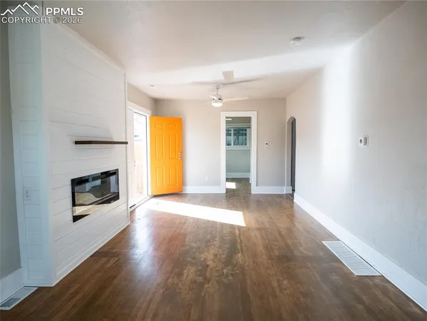 an empty room with windows and a fireplace