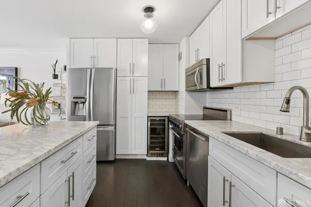a kitchen with stainless steel appliances white cabinets and a sink