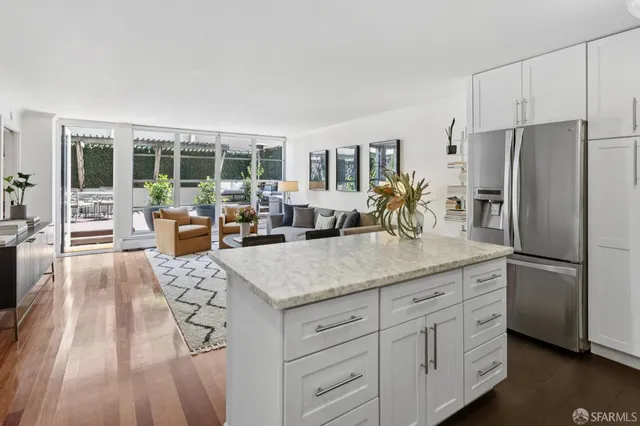 a kitchen with stainless steel appliances granite countertop a lot of counter space and wooden floors