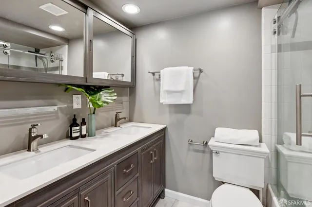a bathroom with a sink a toilet and mirror