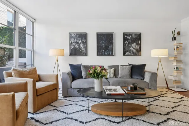 a living room with furniture a lamp and a large window