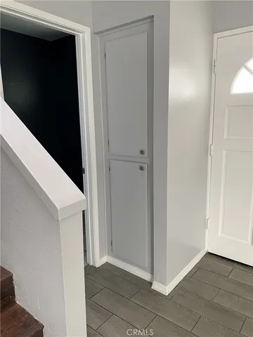 en empty room with wooden floor and chandelier