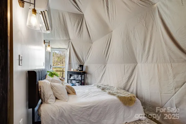a bedroom with a bed a flat screen tv and a table
