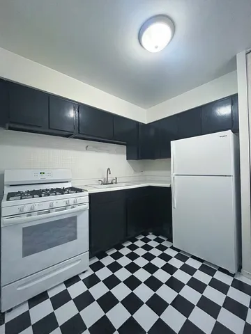 a kitchen with a stove a refrigerator and a cabinets