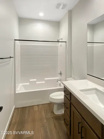 a bathroom with a sink a toilet a mirror and bathtub