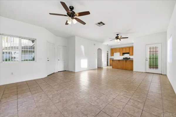a view of empty room with wooden floor and windows