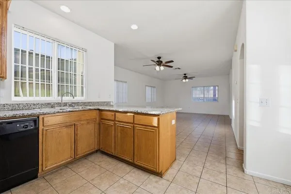 a kitchen with stainless steel appliances granite countertop a sink dishwasher stove and cabinets