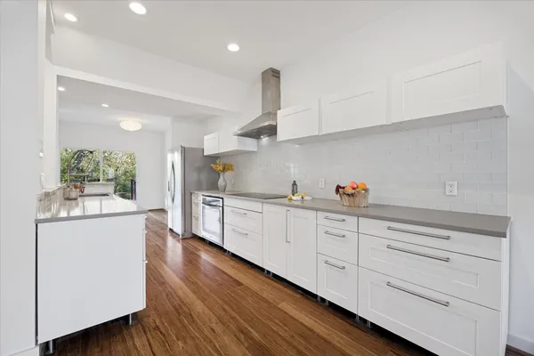 a kitchen with granite countertop white cabinets and white appliances