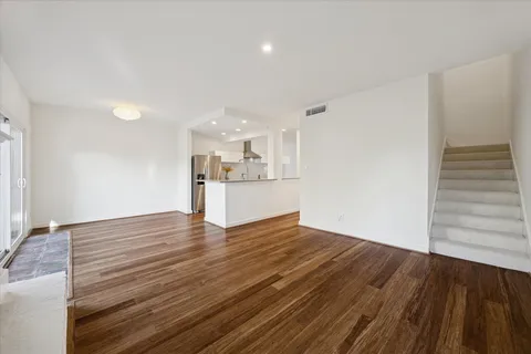a view of a kitchen with wooden floor and a sink