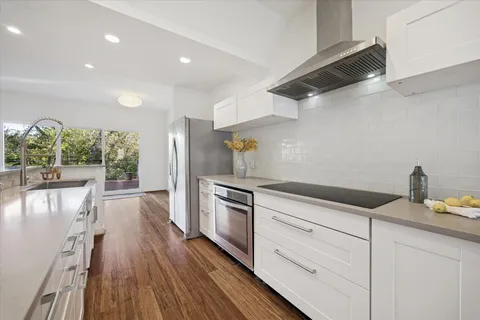 a bathroom with a granite countertop sink a mirror and shower