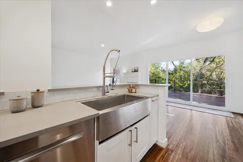 a kitchen with a sink and wooden floor