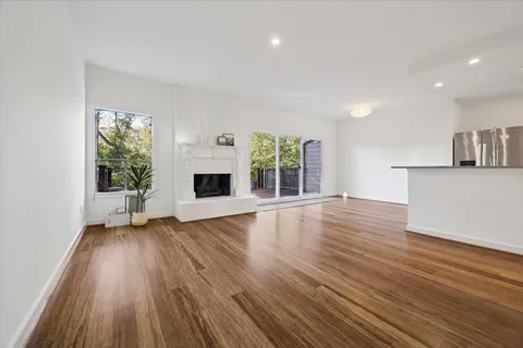 an empty room with wooden floor and a fireplace
