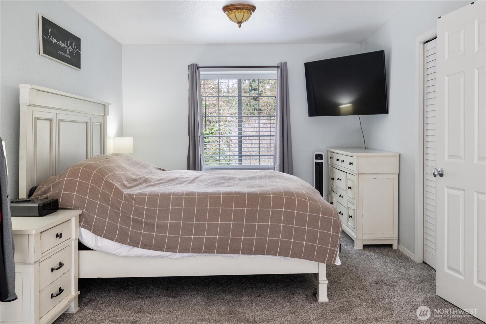 17018 45th Street East Lake Tapps, WA 98391 - Photo 19 of 40 a bedroom with a bed and a flat tv screen in it