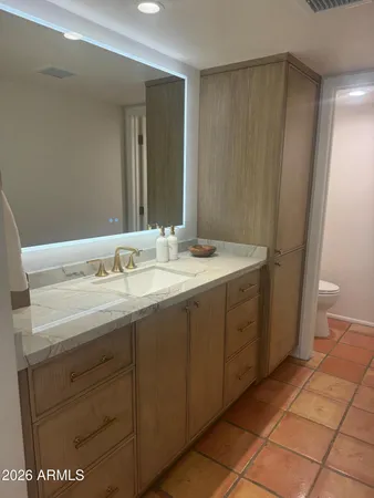 a spacious bathroom with a granite countertop sink and a mirror