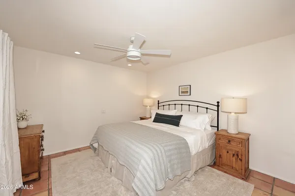 a bedroom with a bed and a ceiling fan