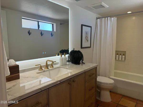 a bathroom with a granite countertop sink a toilet and a bathtub