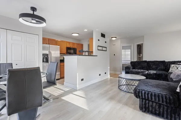 a living room with stainless steel appliances kitchen island granite countertop furniture and a refrigerator