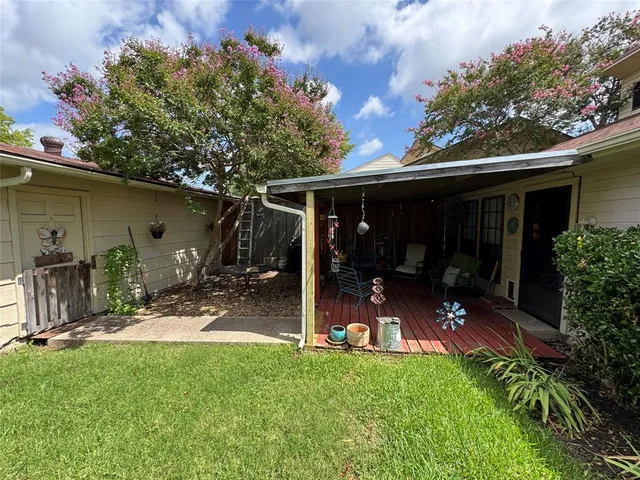a view of a chair and table in backyard of the house